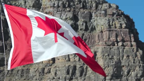 Canadian Flag Waving Proudly against Mountain Background