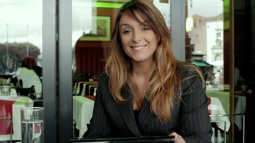 Woman Uses Tablet Device in Modern Cafe