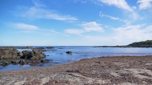 A time-lapse of the incoming tide on a rocky beach with blue skies on a southern ocean beach.