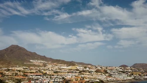 Beautiful Seaside with Mountains In The Background And Buildings At the Side Blue Sea Drone Shot
