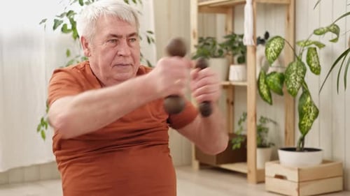 Mature Man Exercising with Dumbbells in Home