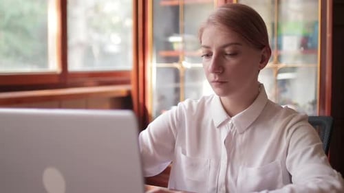 Focused Businesswoman Working on Laptop Computer in Home Office