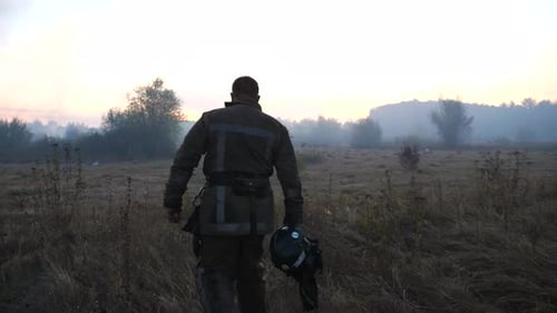 Firefighter Walking Through Rural Field at Sunrise