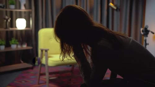 Silhouette of a woman sitting and looking distraught