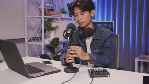 Young podcast creator setting up audio equipment in modern studio