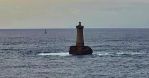 Eine rotierende Luftaufnahme von Phare Du Four, einem Leuchtturm in der Bretagne, Frankreich, ein antiker Leuchtturm, der noch steht