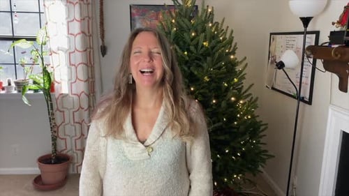 Woman Smiling in Front of Christmas Tree at Home