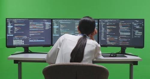 Asian Woman Developer Boring While Write Code With Multiple Computer Screens In Green Screen Studio