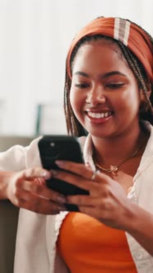 Smiling Young Woman Using Mobile Phone Indoors