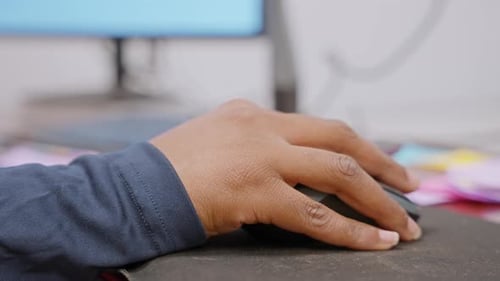 Person Using Computer Mouse at Office Desk