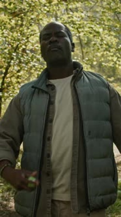 Man Standing in Forest With Green Container