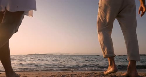 Romantic Couple Walking and Kissing on Beach at Sunset