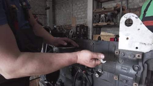 Man Repairing Engine in Industrial Workplace