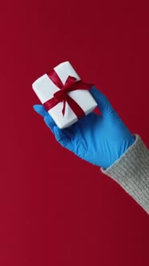 Hand in Glove Holds Wrapped Gift