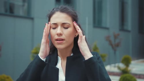 Young Pretty Woman Business Executive Standing Outside Office Building Suffering Headache Massaging