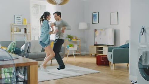 Young Couple Joyfully Dancing Together at Home