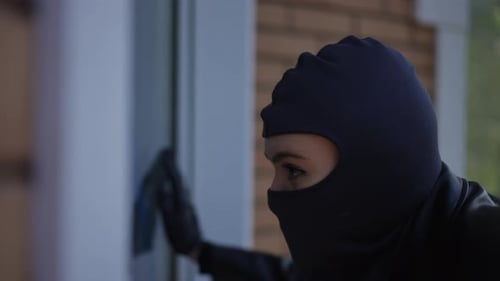 Woman in Balaclava with Flashlight Prying at Window