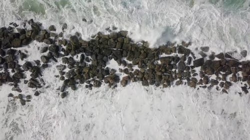 Massive Storm waves hitting and passing a wave breaker
