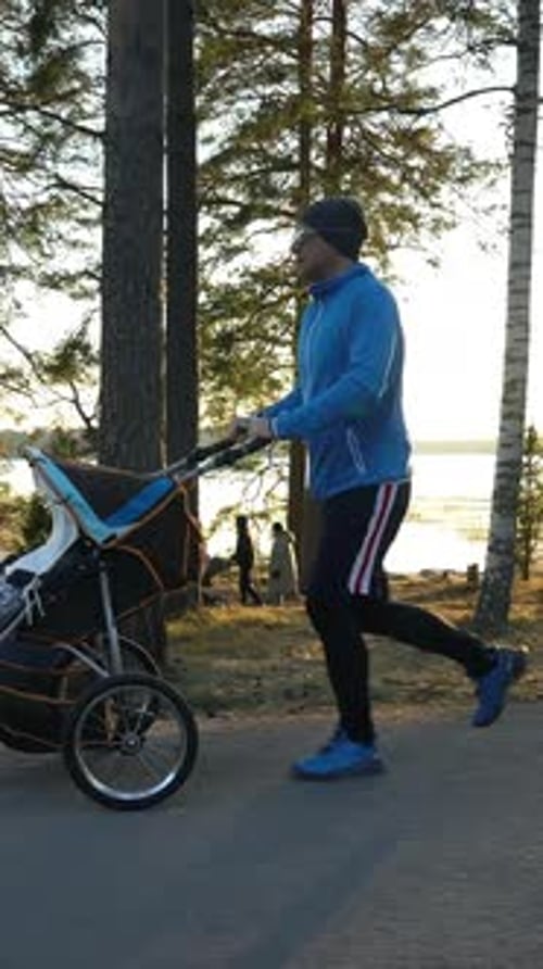 Männlicher Läufer, der mit einem Kinderwagen joggt