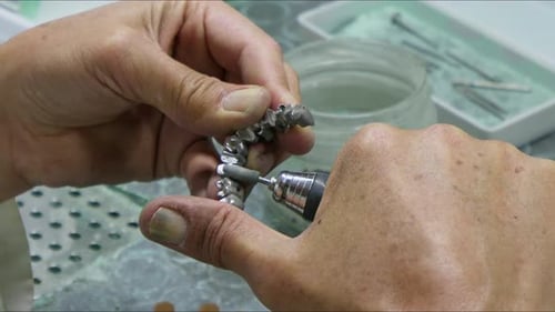 Hands Modify Dental Apparatus in Brightly Lit Workplace