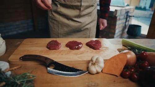 Chef Seasoning Raw Meat with Vegetables
