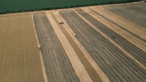 An Aerial View of Vast Agricultural Fields Showcasing Various Harvesting Machines at Work