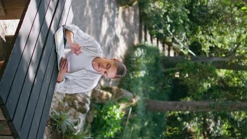 Woman Sitting Park Table Park with Smartphone Writing Into Notebook Vertically