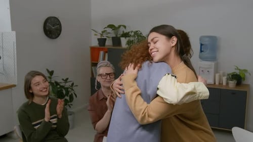 People Hugging at an Indoor Gathering