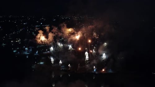 Grupo de fuegos artificiales que explotan en el cielo nocturno de República Dominicana. Toma aérea de arriba hacia abajo.