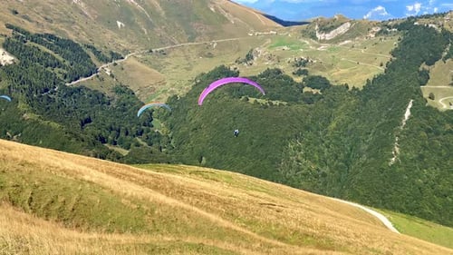 Paraglider take off and flying above mountains
