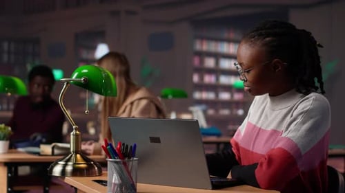 Young Scholar Focuses on Exam Preparations in the Campus Library with Colleague