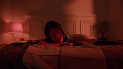 Upset Woman Crying on Bed in Dark Room