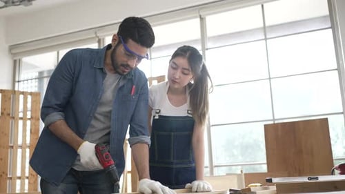 Craftspeople Working with Wood in a Bright Workshop