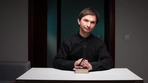 Man With Book and Prayer Beads Indoors