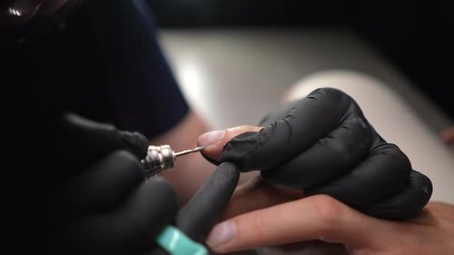 Manicurist Shaping Fingernail with Electric File Close Up