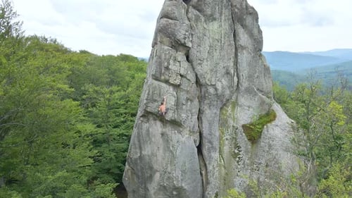Strong Male Climber Climbing Steep Wall of Rocky Mountain