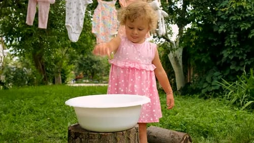The Child is Washing Clothes in the Garden Selective Focus