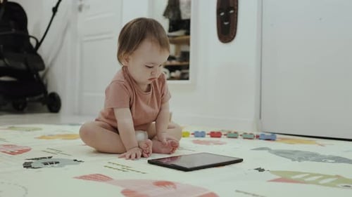 Adorable Infant Focused on Tablet Indoors