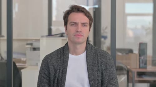 Young Man Experiencing Headache Pain in Office