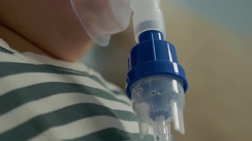Kind, das zu Hause eine Lösung zur Hustenbehandlung mit einem Vernebler inhaliert