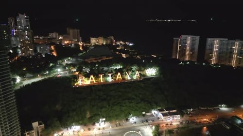 City at Night, beach of Pattaya Thailand, modern logo buildings in Green tropical Beach