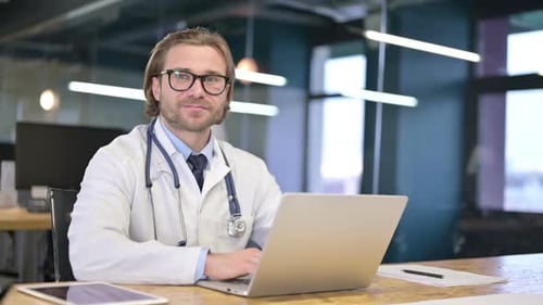 The Happy Doctor Smiling and looking at Camera in Clinic