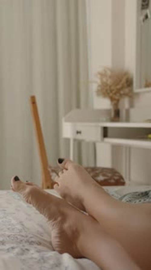 Adult relaxing in bed, showing feet