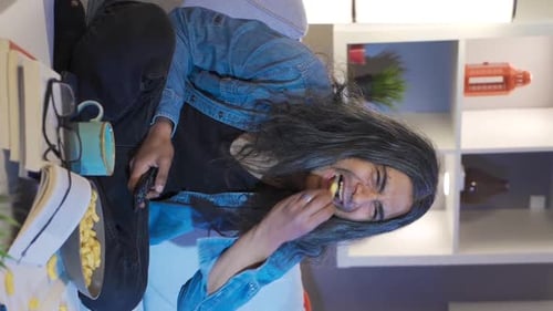 Smiling Young Adult Sitting on Couch with Pasta