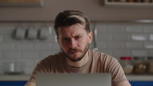 Tired Man Working on Laptop at Home