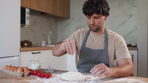 Man Kneading Dough in Modern Kitchen at Daytime
