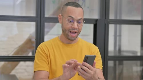 Excited Man Celebrates Good News on Smartphone
