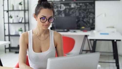 Cute 30s Lady Working at Wooden Desk in Trendy Hipster Startup Office