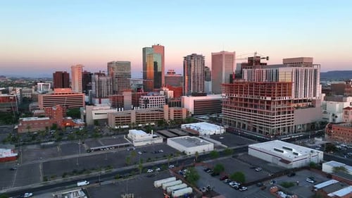 Sunset over Phoenix, Arizona skyline. Cinematic aerial establishing shot of downtown skyscrapers.