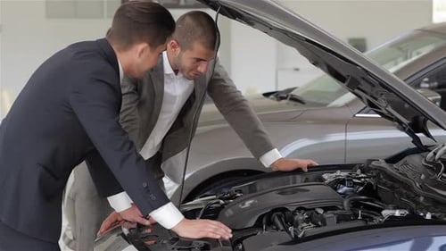 Men Examine Car Engine at Dealership